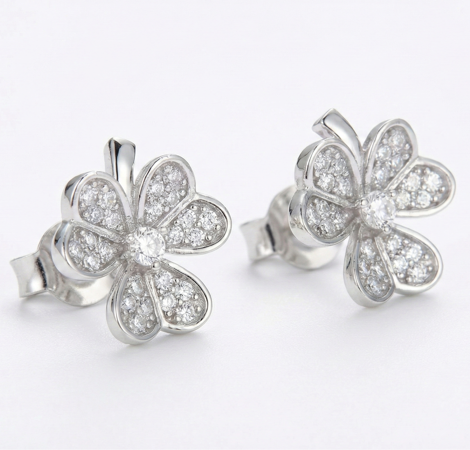 Silver flower-shaped earrings on a white background